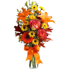 Orange lilies and roses with yellow daisies in a glass vase