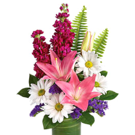 Pink lilies and white daisies in a green glass vase