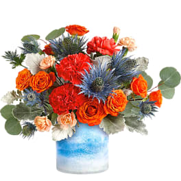 Orange and red bouquet in a blue glass vase