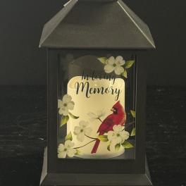 Black lantern with a candle and "In Loving Memory" card