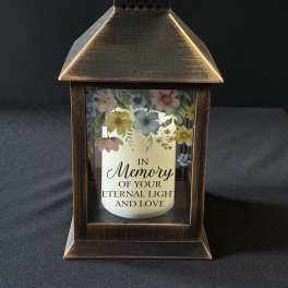 Bronze lantern with a memorial candle and pastel floral print