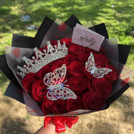 Bouquet of red roses with a jeweled crown and butterfly decorations
