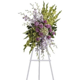 Tall floral spray with purple roses and green orchids on a stand