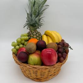 Fruit basket with pineapple, bananas, grapes, kiwi, oranges, apples, and pears