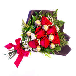 Bouquet of red roses with chocolates and a pink ribbon