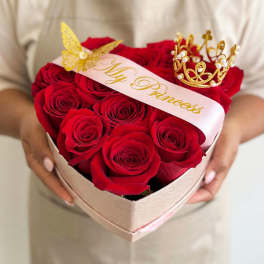 Heart-shaped box of red roses with a "My Princess" ribbon and gold crown toppers