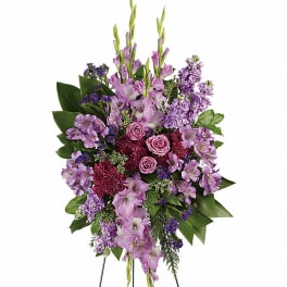 Tall lavender and purple standing spray with roses and mixed flowers on a green metal easel