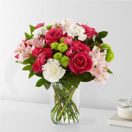 Bouquet of pink roses, carnations, and alstroemeria in a clear glass vase