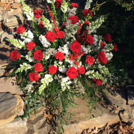 Large outdoor floral arrangement with red roses and white snapdragons