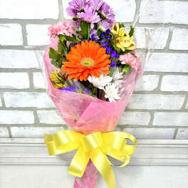 Colorful mixed bouquet with a large orange gerbera daisy and pink ribbon wrap