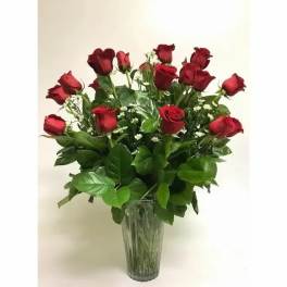 Red roses arranged in a clear glass vase