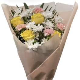 Bouquet of yellow roses, white daisies, and pink carnations wrapped in tan paper
