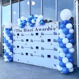 Blue and white balloon columns framing a Bizzi Awards backdrop
