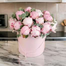 Pink peonies in a pale pink hatbox with eucalyptus