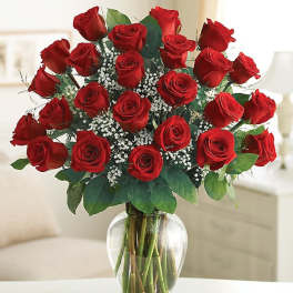 Bouquet of red roses with baby's breath in a clear glass vase