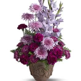 Purple and lavender flowers arranged in a decorative vase