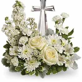 White floral arrangement with a silver cross topper
