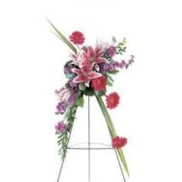 Standing floral spray with pink and purple flowers on an easel
