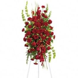 Tall standing arrangement of red roses with green accents on an easel