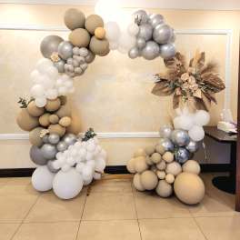Balloon arch in beige, white, and silver with dried floral accents