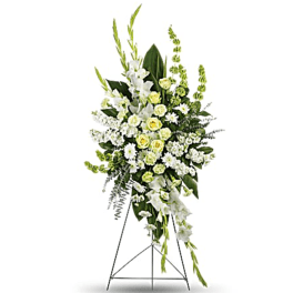 Tall white and pale yellow funeral spray on a stand