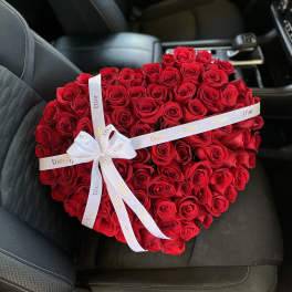 Heart-shaped bouquet of red roses with a white Dior ribbon