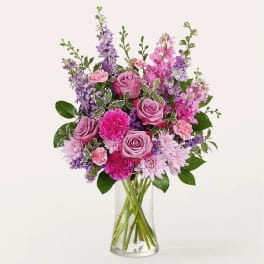 Pink and purple mixed flower bouquet in a clear glass vase