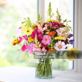 Mixed bouquet of colorful flowers in a clear glass vase