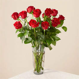 Red roses arranged in a clear glass vase