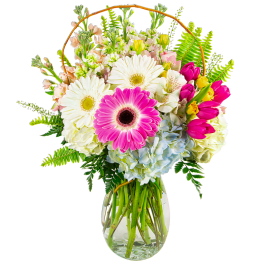 Mixed bouquet with gerbera daisies, tulips, hydrangeas, and ferns in a glass vase