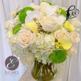 White and pale peach bouquet with green mums in a glass vase