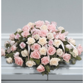 Casket spray of pink and white roses with ribbon accents