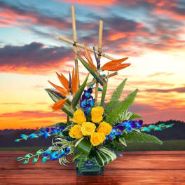 Tropical flower arrangement with yellow roses and orange bird-of-paradise in a vase