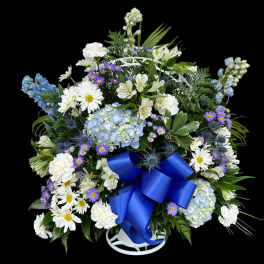 Blue and white floral standing spray with a large blue ribbon