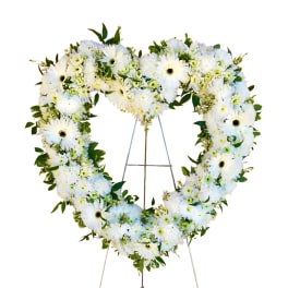 Heart-shaped white floral wreath on a metal stand