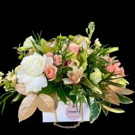 Mixed bouquet of white and pink flowers in a white gift bag