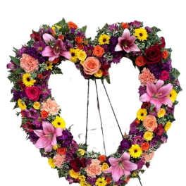 Heart-shaped floral wreath on a stand with pink lilies and mixed blooms