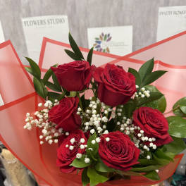 Bouquet of red roses with white baby's breath in red wrap