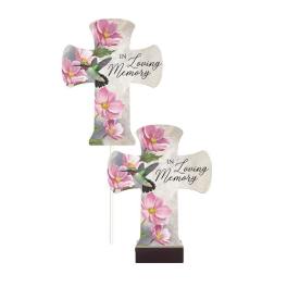 Two cross-shaped memorial plaques with pink flowers and hummingbirds