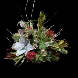 Holiday floral arrangement with red blooms and silver ornaments