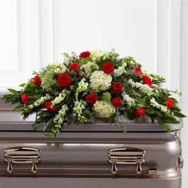 Red roses and white flowers arranged on a casket