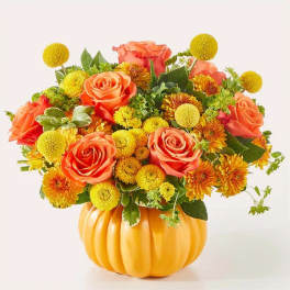 Orange roses and yellow mums in a pumpkin-shaped vase