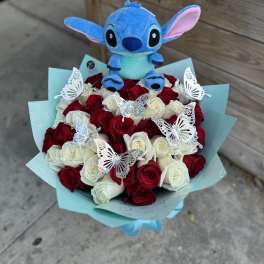Bouquet of red and white roses with silver butterflies and a blue plush character in aqua wrapping paper