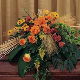 Large orange and yellow floral arrangement with roses and lilies