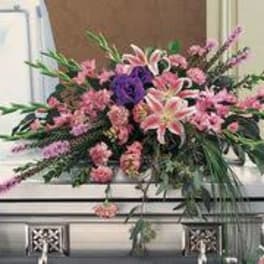 Large pink and purple floral casket spray with lilies and mixed blooms