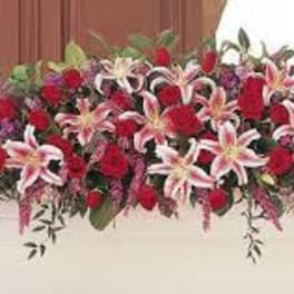 Long floral arrangement with red roses and pink lilies