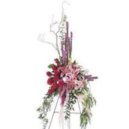 Tall floral standing spray with red and pink flowers on an easel