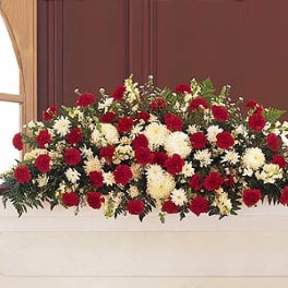 Red and white floral casket spray with mixed blooms