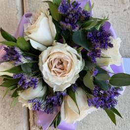 Bouquet of cream roses with purple filler flowers and lavender wrap