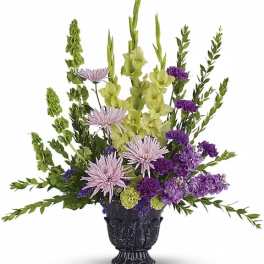 Purple and green floral arrangement in a black urn vase